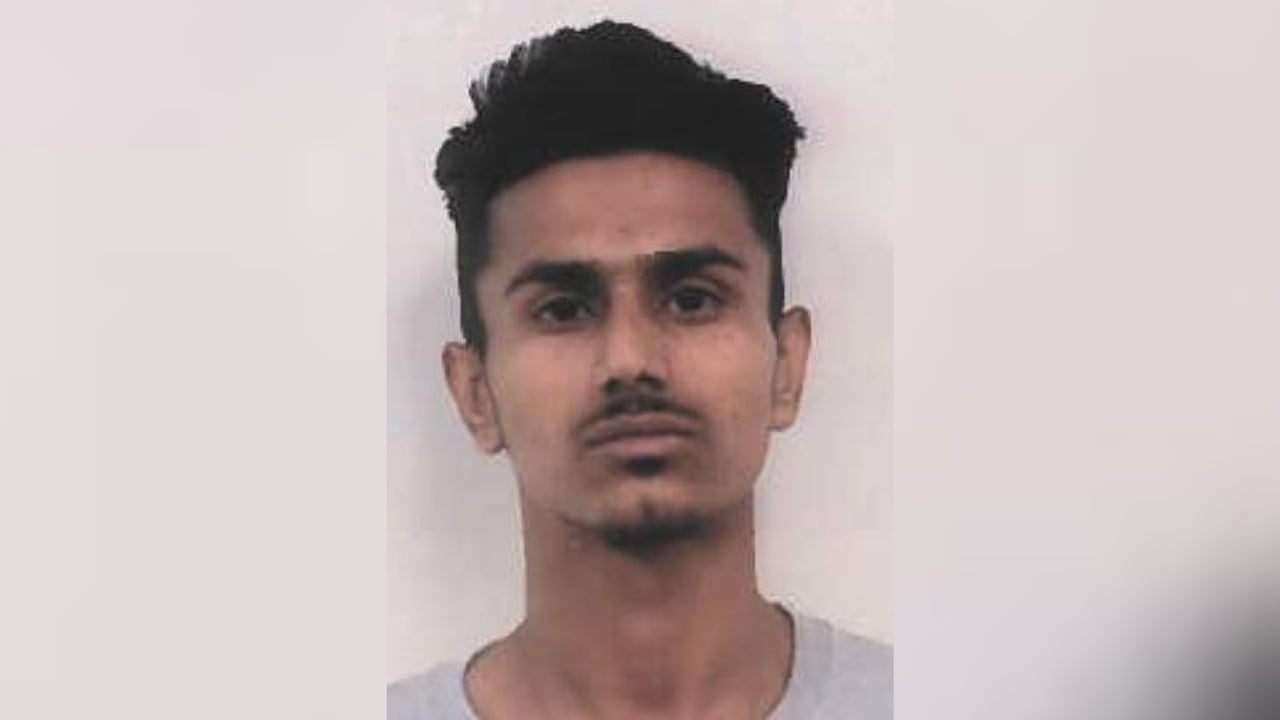 A mugshot of a South Asian man.