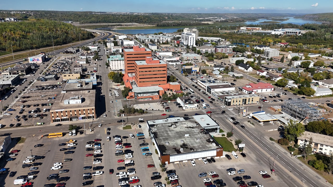 Parking lots and buildings are shown with a river in the distance.