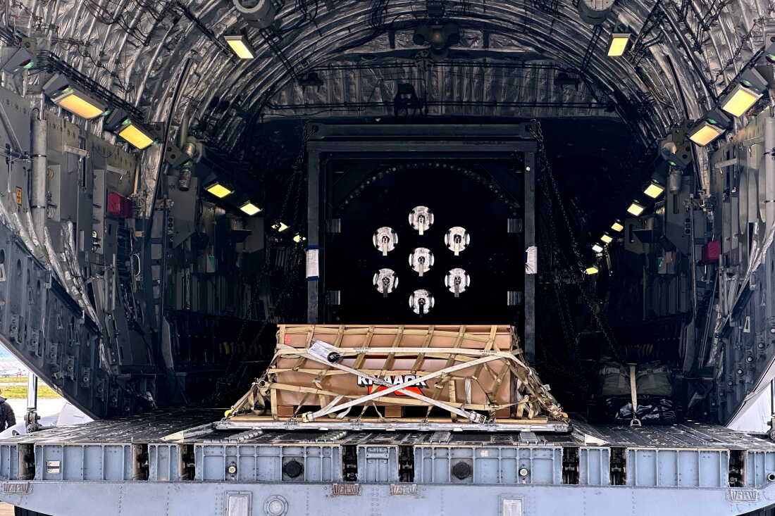 A Valar Atomics microreactor is strapped on a pallet inside a C-17 aircraft at March Air Reserve Base in California on February 15. The microreactor is in a box that's on the pallet, and multiple straps secure the box onto the pallet.