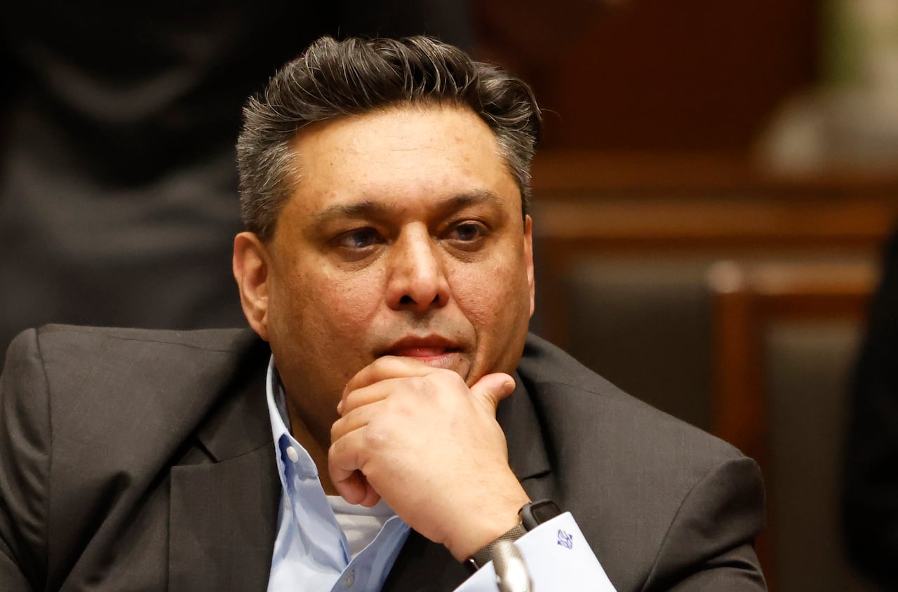 A man in a suit rests his chin in his hand