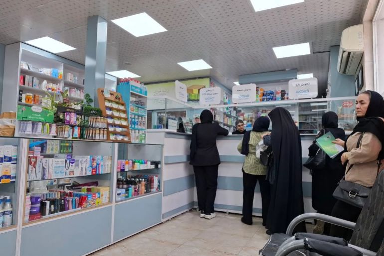 Women queue at a pharmacy in Tehran [Al Jazeera]