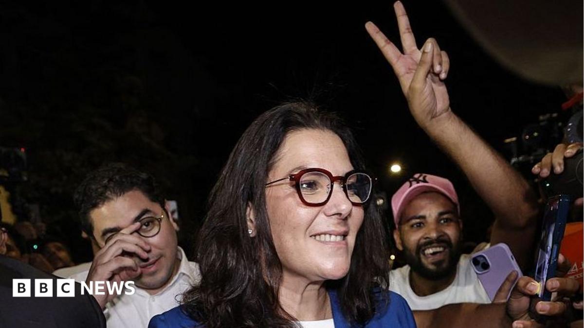 Fatima Zahra El Mansouri wearing a blue blazer over a white shirt. She is surrounded by celebrating crowds of men after the announcement of the provisional results of the legislative elections in the early hours of 24 September 2026.