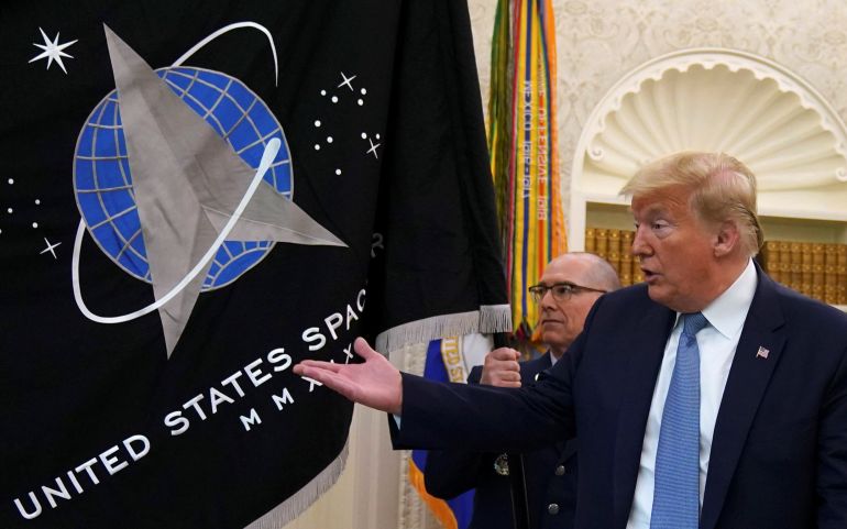 US President Donald Trump gestures towards the US Space Force flag during a presentation of the flag in the Oval Office of the White House in Washington, DC, the US, May 15, 2020