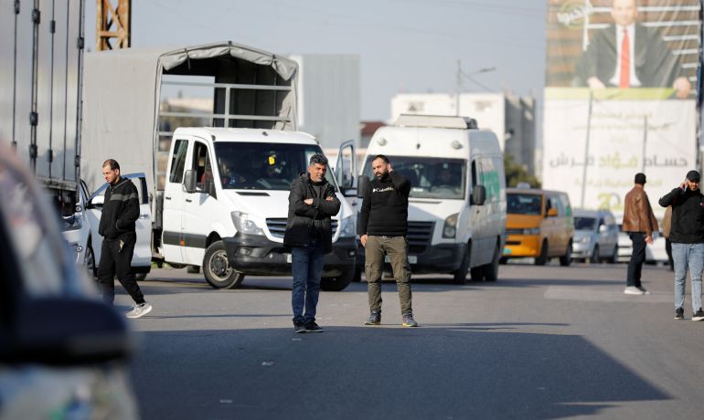 People wait at a Hawara checkpoint near Nablus, after it was closed following a shooting near Hawara in the Israeli-occupied West Bank