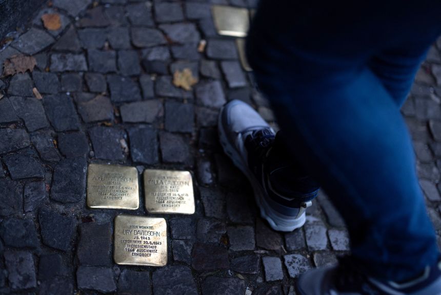 A person steps across 'Stolpersteine' at Scheunenviertel quarter in Berlin.