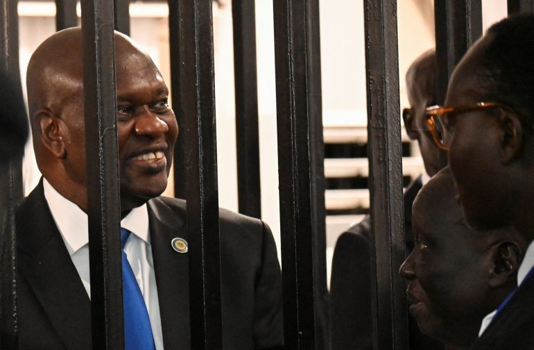South Sudan’s suspended First Vice President Riek Machar stands inside a steel caged dock as he talks to his legal counsel before his trial on charges including treason and crimes against humanity, at the Freedom Hall in Juba, South Sudan, September 22, 2025. REUTERS/Stringer