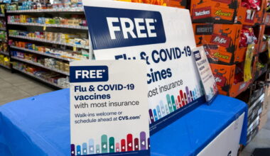 Signs advertise flu and COVID-19 vaccines at a CVS pharmacy in New York