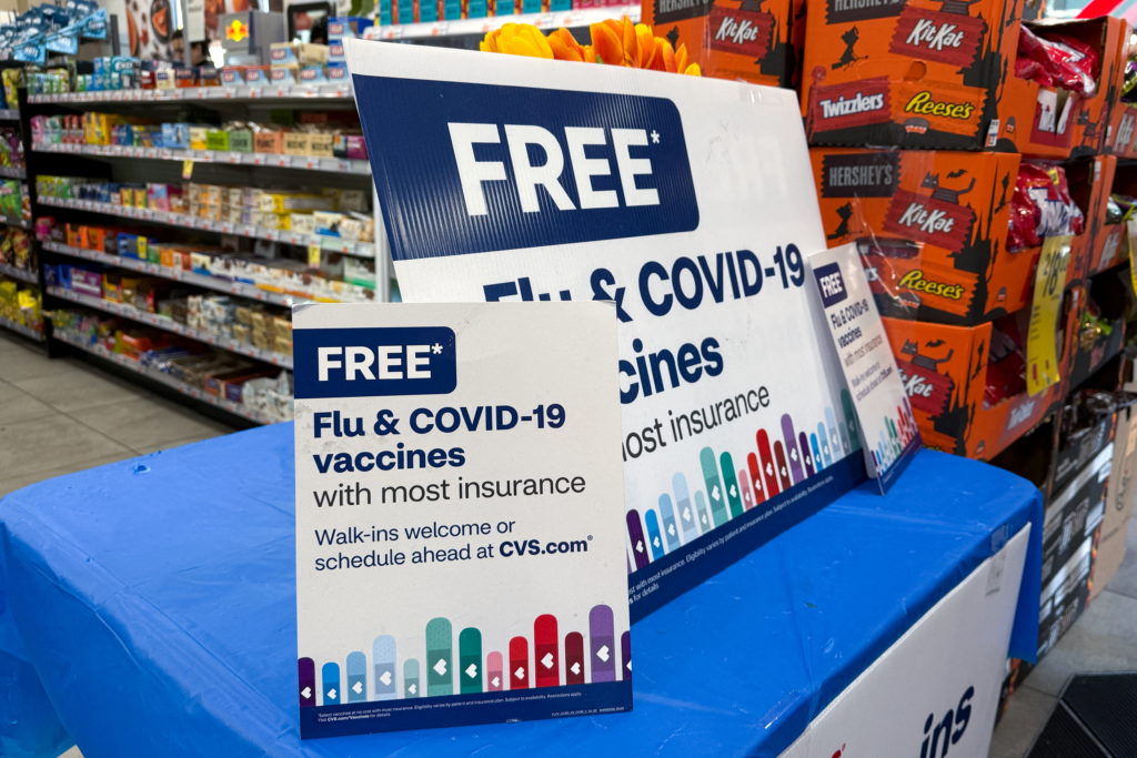 Signs advertise flu and COVID-19 vaccines at a CVS pharmacy in New York