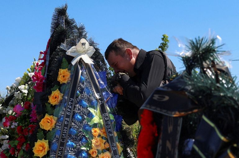 Petro Ionov reacts near a grave of his son Yevhenii Ionov after a burial ceremony on a cemetery in the town of Bilohorodka, amid Russia's attack on Ukraine, in Kyiv region, Ukraine August 25, 2026. Yevhenii Ionov was among at least seventeen people killed by Russian missile and drone strikes towards Kyiv on August 20, according to mayor Vitali Klitschko. Civilian casualties from Russia's full-scale invasion rose sharply in July as missiles and drones struck cities far from the front lines, the United Nations said in a report published on August 14. The U.N. Human Rights Monitoring Mission in Ukraine said it had confirmed at least 437 civilians killed and 2,610 injured during the month, a 30% increase from June and the highest toll since May 2022.REUTERS/Anatolii Stepanov TPX IMAGES OF THE DAY