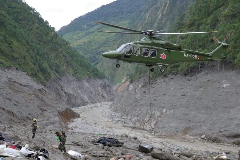 A Nepal Army helicopter flies as army soldiers work during a search and rescue operation outside a tunnel near the Hydropower Project sites in Rasuwa district, Nepal, in this handout obtained on September 2.