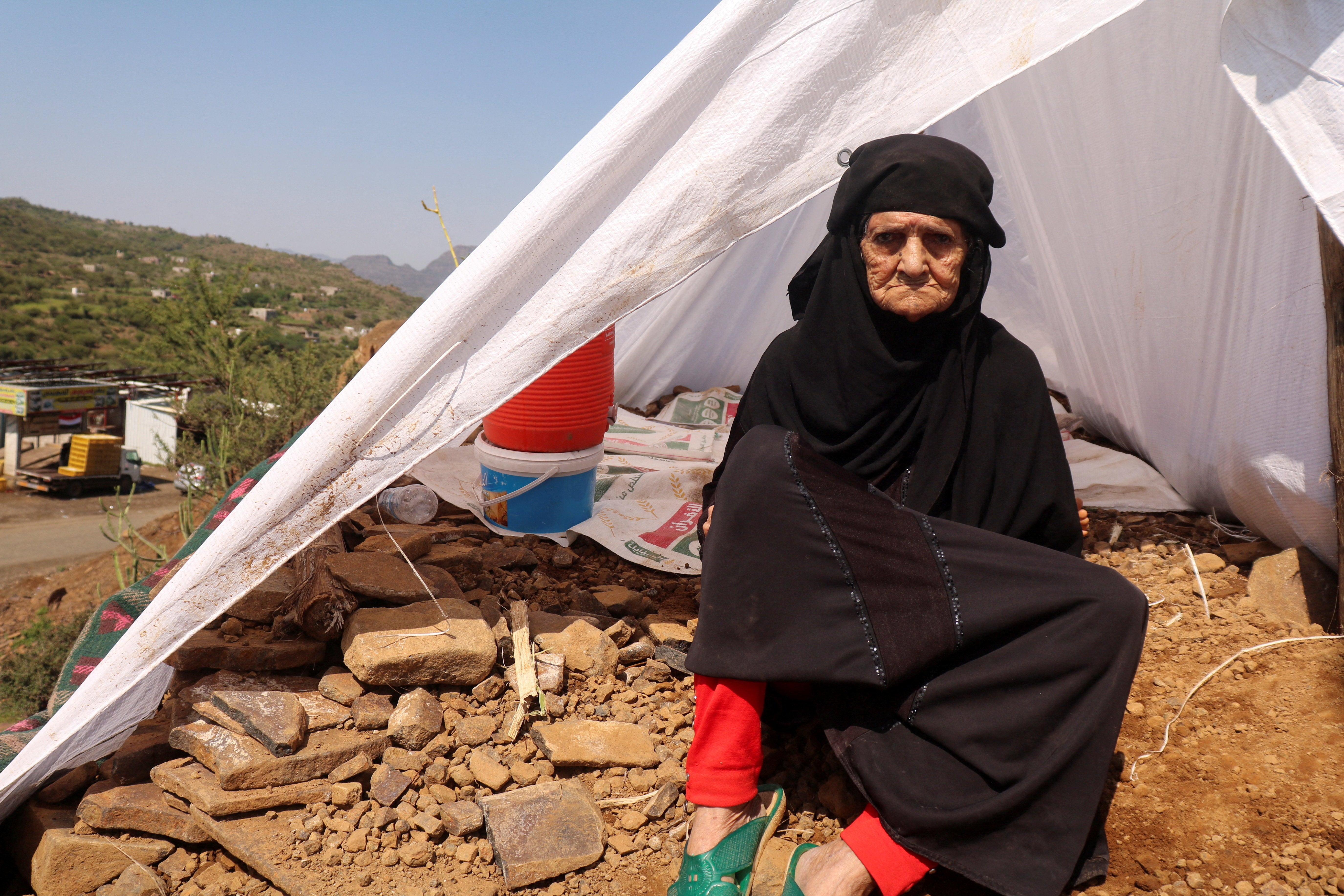 A displaced woman sits outside her tent at a makeshift camp for people displaced by clashes between Iran-aligned Houthi fighters and Saudi-backed Yemeni government forces, in Taiz province, Yemen