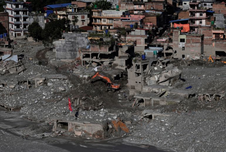 An excavator clears mud from damaged houses following deadly flash floods and a mudslide, in Nuwakot district, Nepal, September 21, 2026 [Navesh Chitrakar/Reuters]
