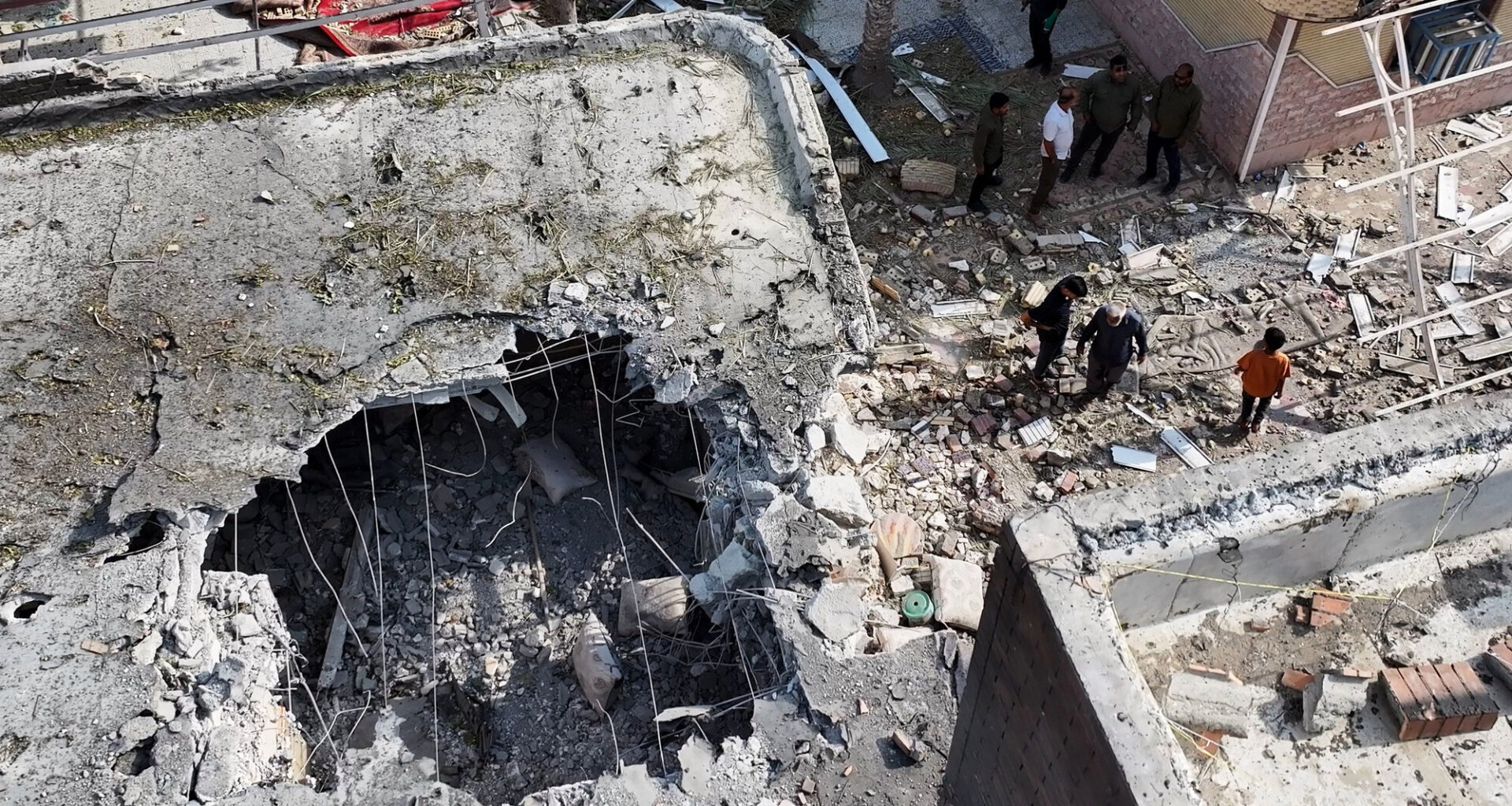 People inspect damage and debris at a building that Iranian media said was hit by a U.S. strike while a wedding celebration was taking place there, in Kuhestak, southern Iran, Wednesday, Sept. 2, 2026.