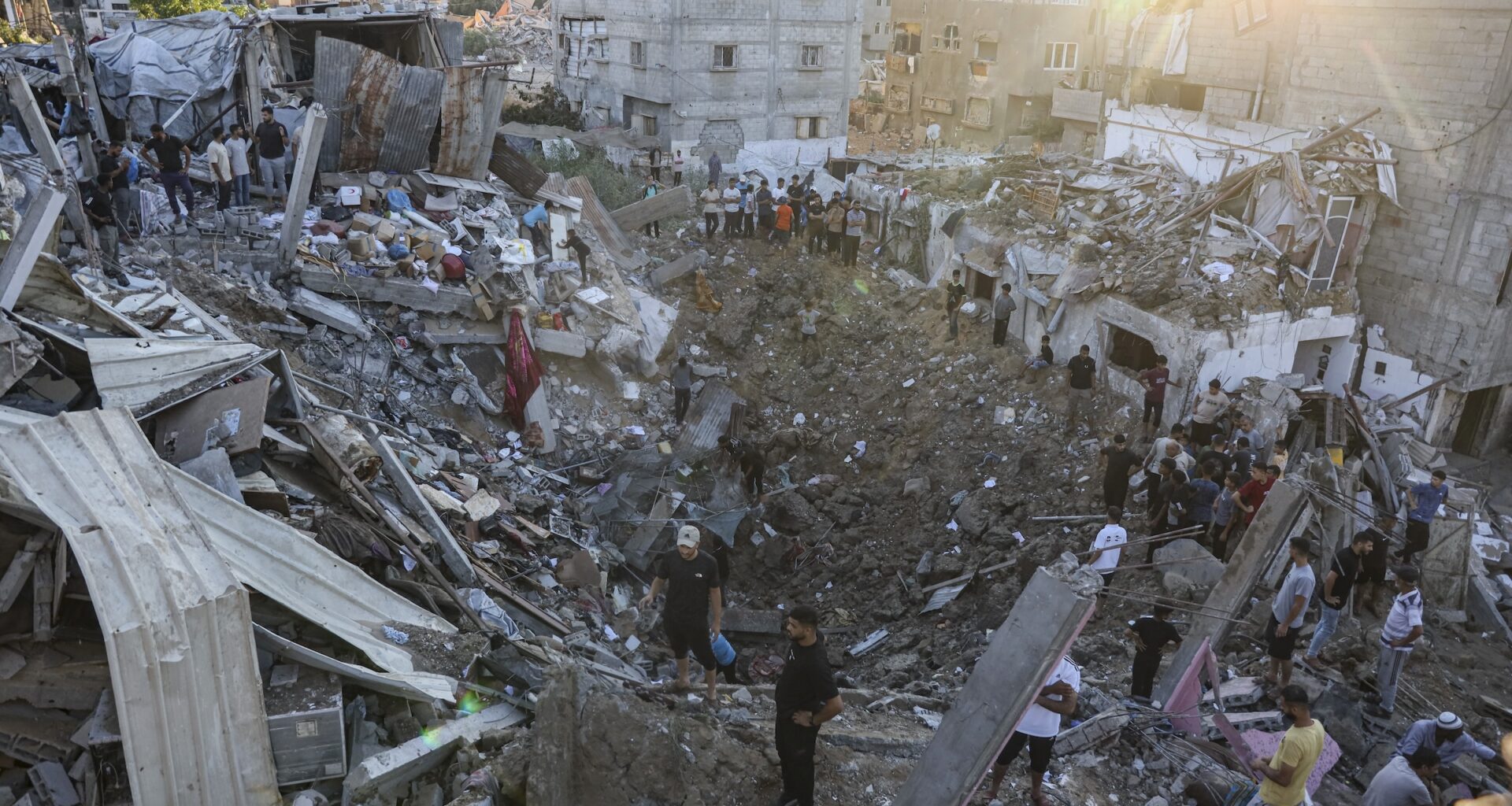 Palestinians gather around a crater and destroyed buildings at Al-Bureij Camp in Gaza City, Gaza Strip, on August 24, 2026. An Israeli airstrike allegedly destroyed a family's home in the camp, killing a child and injuring several others amid continued strikes across the territory.