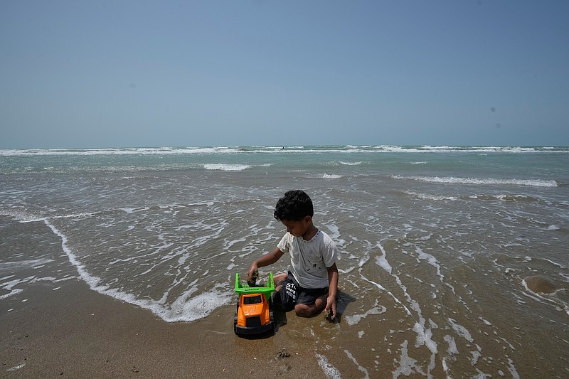 A boy plays with a toy truck on a beach along the Strait of Hormuz in Kuhestak, Iran, Friday, Sept. 4, 2026. (AP Photo/Vahid Salemi)