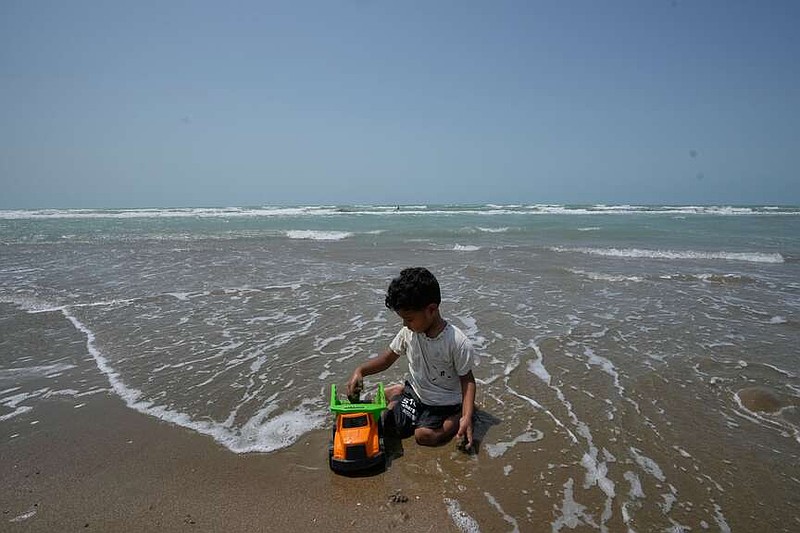 A boy plays with a toy truck on a beach along the Strait of Hormuz in Kuhestak, Iran, Friday, Sept. 4, 2026. (AP Photo/Vahid Salemi)