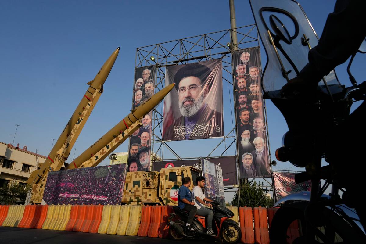Motorbikes drive past Iranian missiles and banners showing portraits of the Iranian Supreme Lea ...