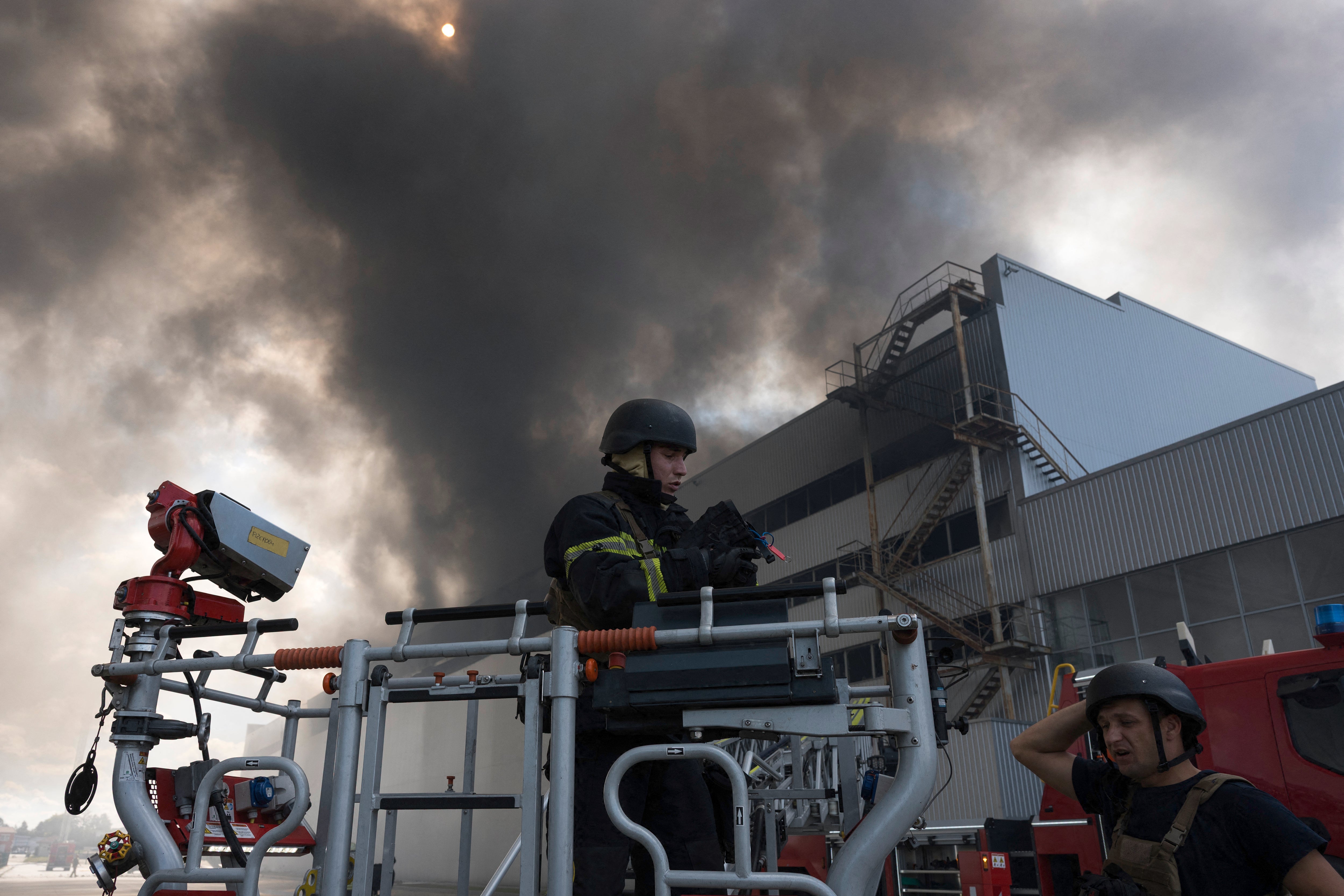 Ukrainian rescue personnel extinguish a fire in an auto parts warehouse following an air attack in Kyiv