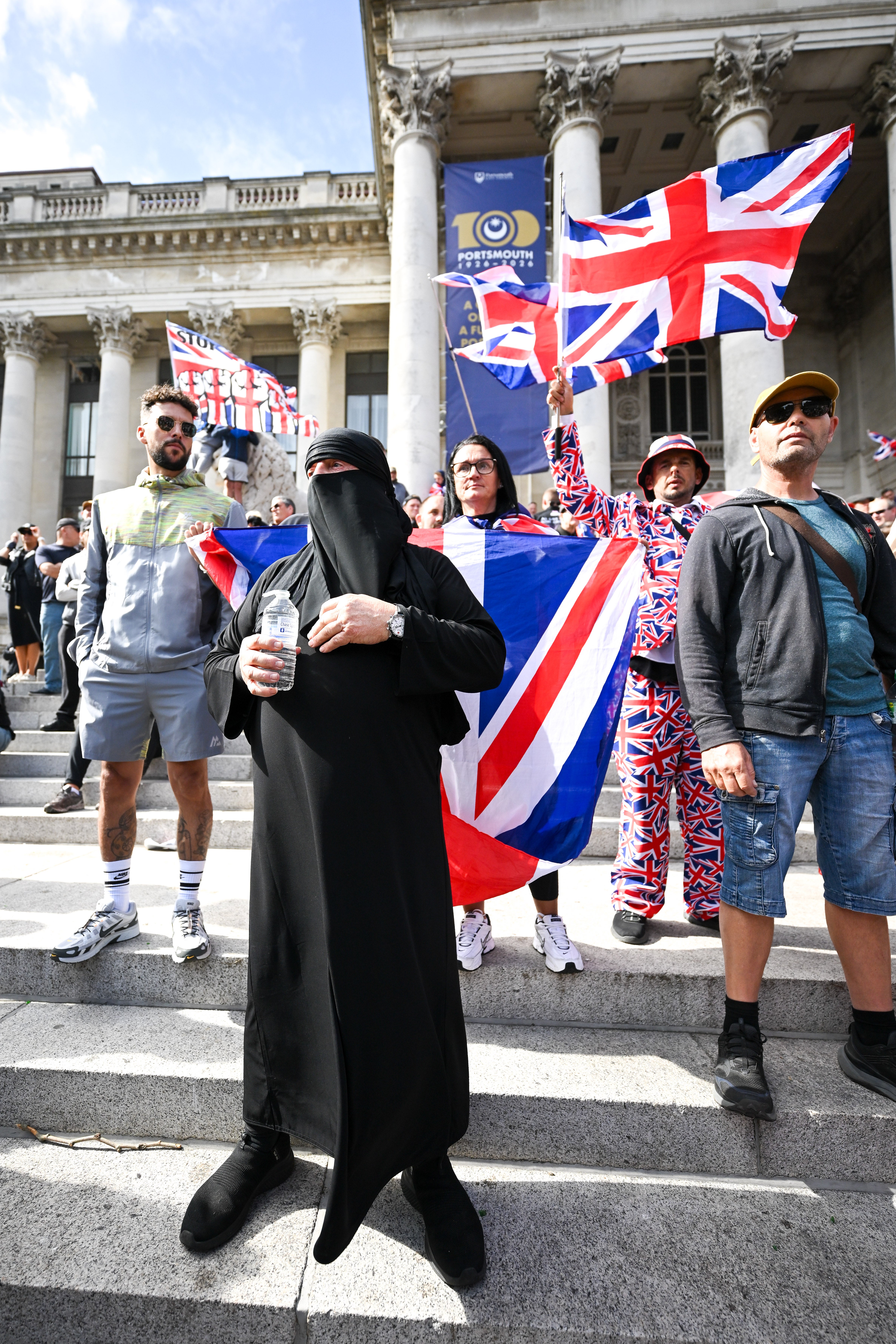 An anti-migrant protester wears a burkha during an anti-migrant march through the city to Guildhall