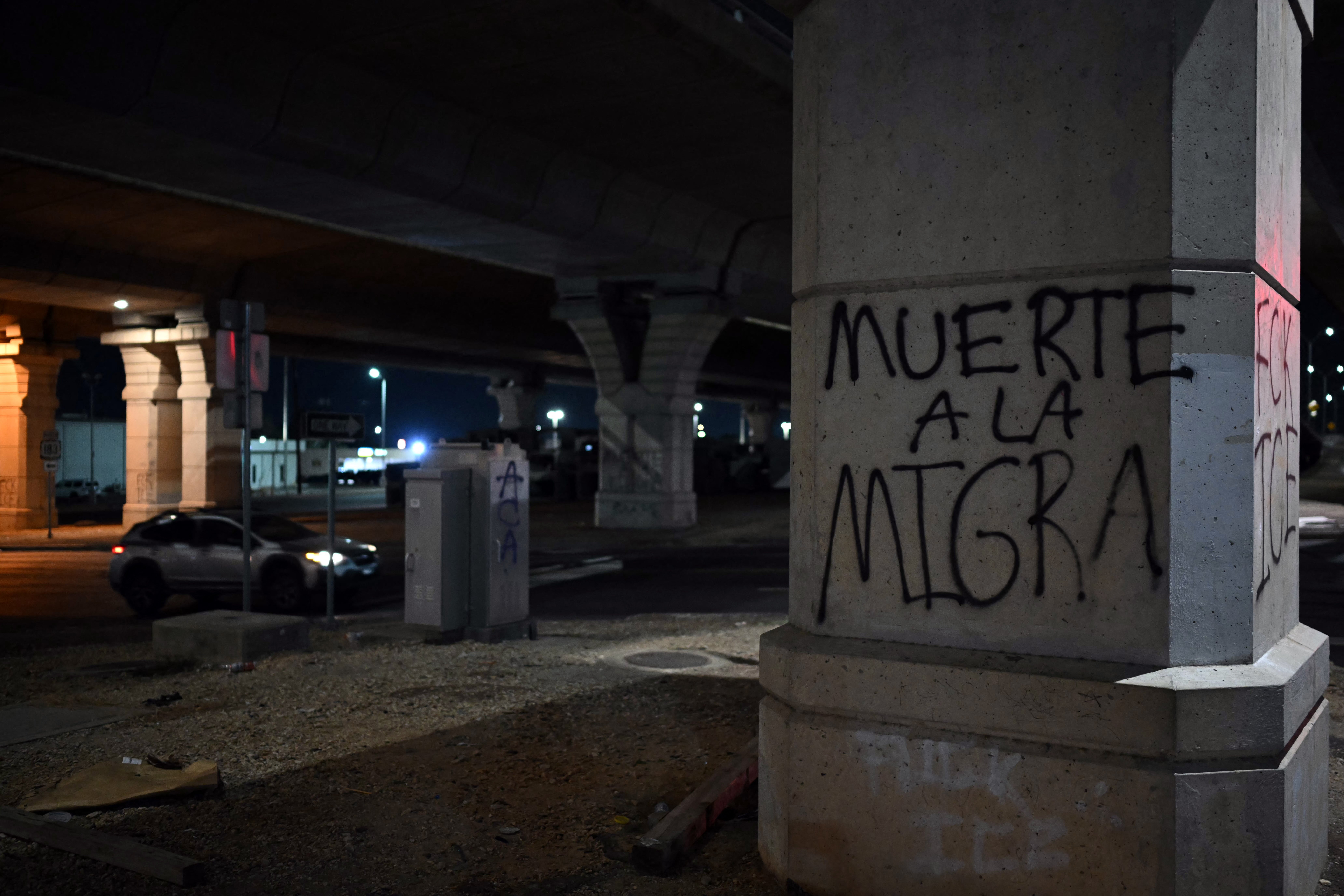 Graffiti at the site of the shooting reads 'death to the immigration police', on 20 September