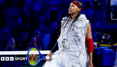 Naomi Osaka wears a red-and-black headband and elbow sleeves similar to those worn by Allen Iverson
