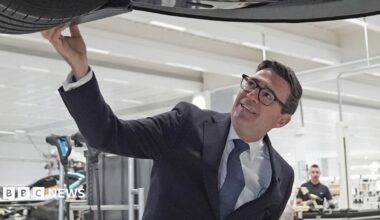 Prime Minister Andy Burnham looks at a car on the production line during a visit