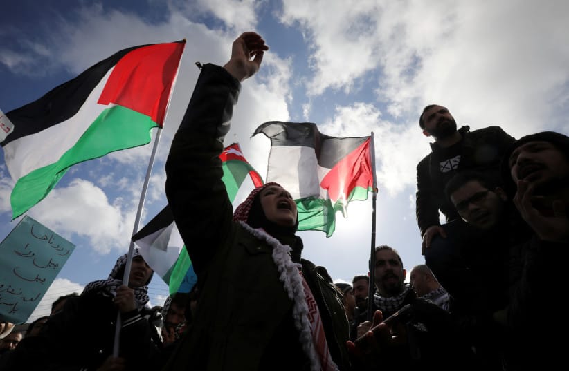 Protesters hold Jordanian and Palestinian flags and shout slogans during a protest against US President Donald Trump's proposed Middle East peace plan, near the US Embassy in Amman, Jordan, January 31, 2020.