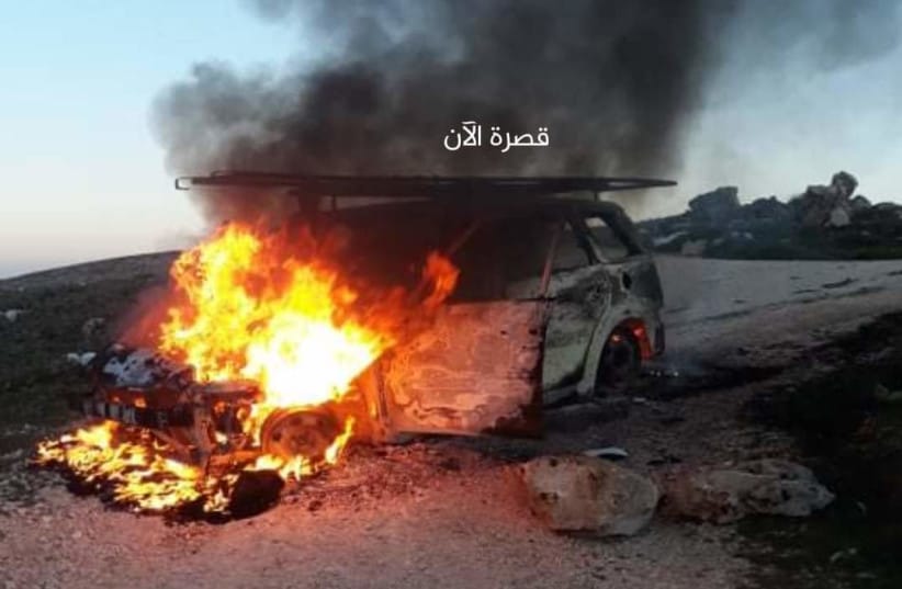A car is seen on fire in the West Bank town of Kusra.