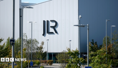 A large white building with the letters JLR in black writing on the side