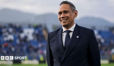 Como president Mirwan Suwarso, wearing a navy blue suit, white shirt and blue tie, smiles on the pitch before the Serie A match against Internazionale