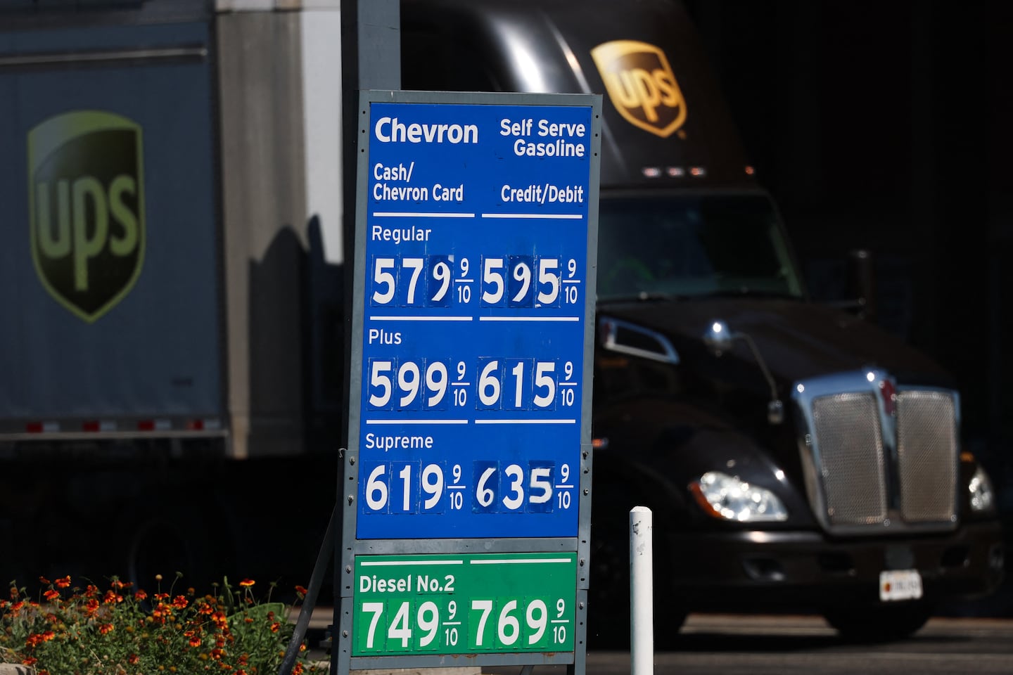 The United Parcel Service Inc. (UPS) logo is seen on a semi-truck as it drives past Chevron diesel prices above $7 a gallon at a gas station in Vernon, California on Aug. 26, 2026. The US and Iran are approaching the six-month mark since military operations began on Feb. 28, 2026, with the two nations remaining entrenched in a strategic stalemate. President Trump has intensified pressure through an aggressive economic isolation campaign, while a 60-day ceasefire and diplomatic window expired without producing a lasting agreement. The conflict's most significant impact on the US economy is the rise in energy costs, which is contributing to higher inflation.