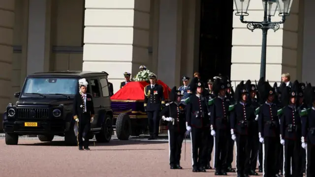 Members of the Royal Guard walk next to the coffin of Norway's King Harald