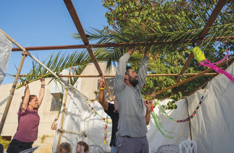 BUILDING A sukkah in Malkia, a kibbutz close to the border with Lebanon, before the holiday.