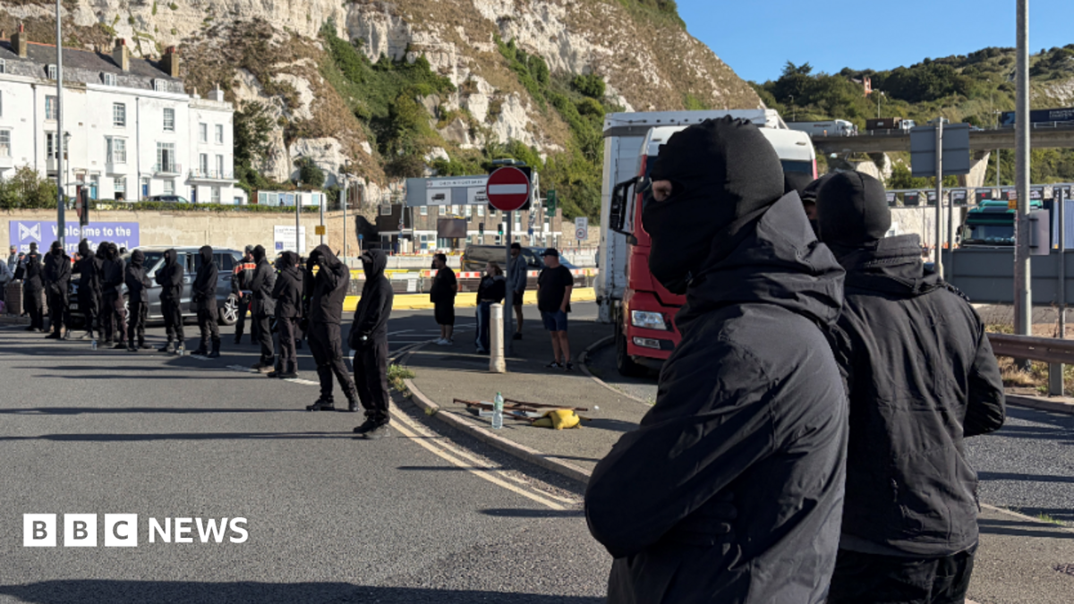 Black-clad and masked demonstrators blocking roads in Dover during a protest.