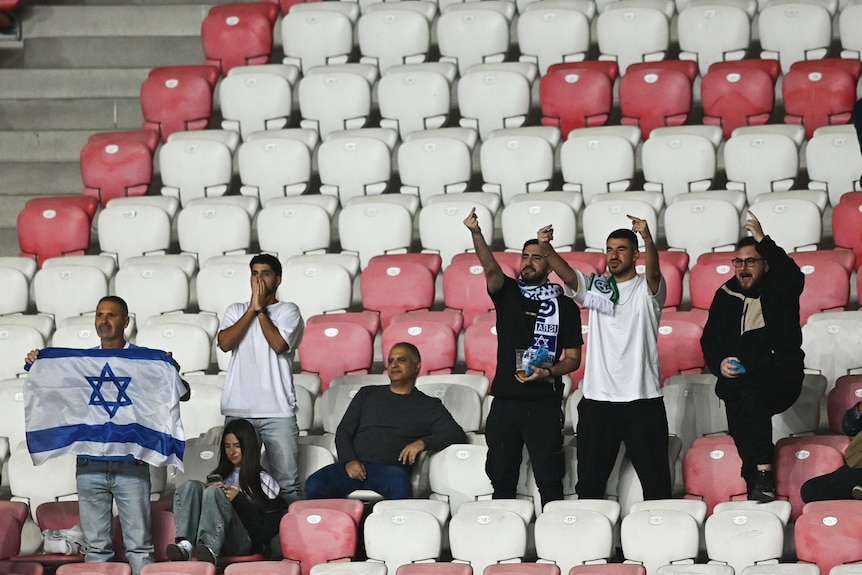 Israel supporters give the finger to Republic of Ireland players at a football game.