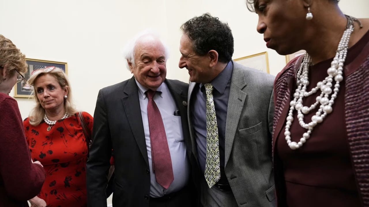 US Rep. Sandy Levin (D-MI) (2nd L) shares a moment with his son Rep.-elect Andy Levin (D-MI) (3rd L), who will succeed him in the 116th Congress, as Rep. Debbie Dingell (D-MI) (L), and Rep. Brenda Lawrence (D-MI) (R) look on after a news conference on auto jobs November 29, 2018; illustrative