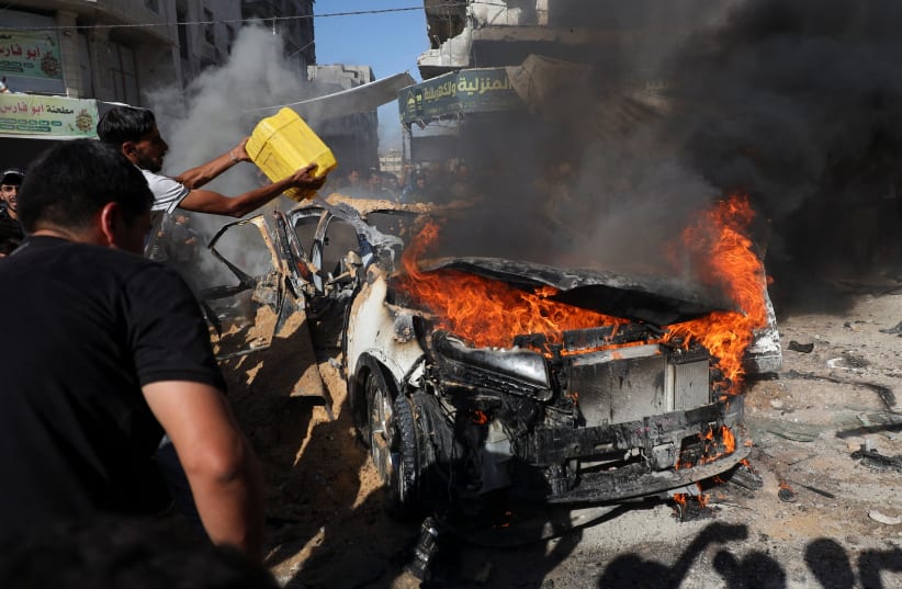 Palestinians attempt to extinguish a fire following an Israeli air strike that hit a vehicle in Gaza City, September 19, 2026.