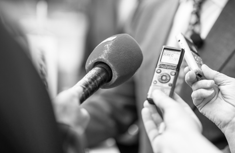 News or press conference or media interview, digital voice recorder and microphone in focus.