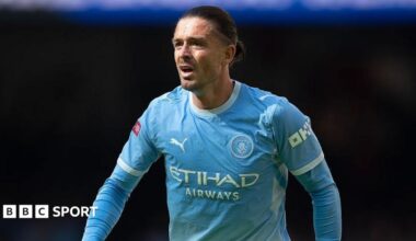 Jack Grealish wearing a blue Manchester City shirt