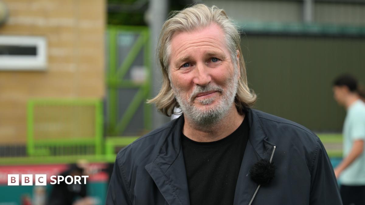 Robbie Savage wearing a black jacket and black top