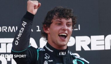 Kimi Antonelli smiles and clenches his right fist in celebration on the podium after winning the Italian Grand Prix
