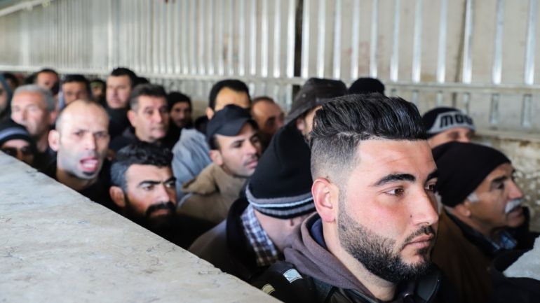 Palestinian men queue at the Checkpoint 300 near Bethlehem