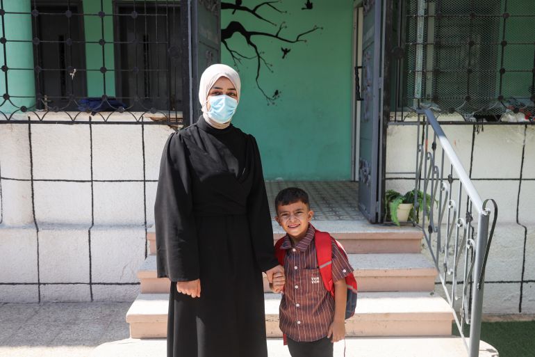 Zahra Saleh stands with her son, Ibrahim, after enrolling him at Abdulaziz private school in Gaza city