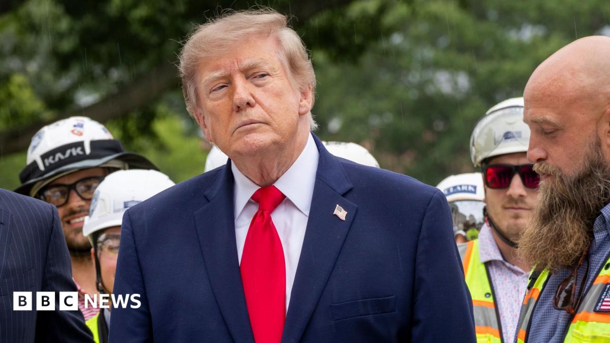 President Trump at the centre of the frame wearing a navy suit
