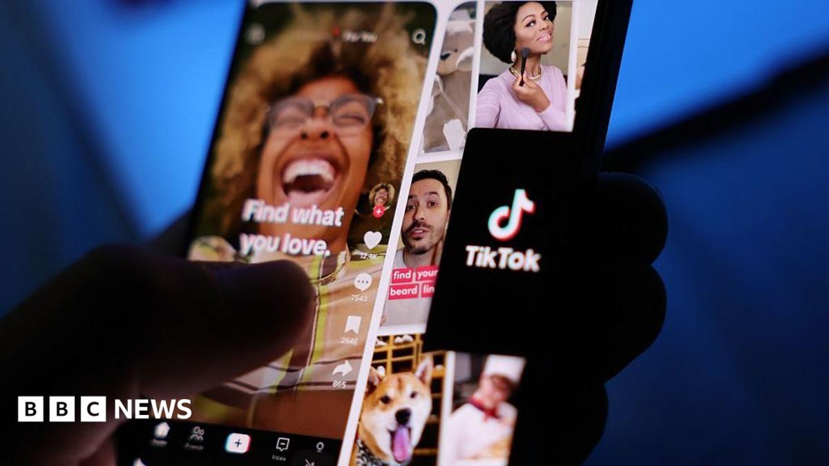 A user holding a smartphone displaying Tiktok content.