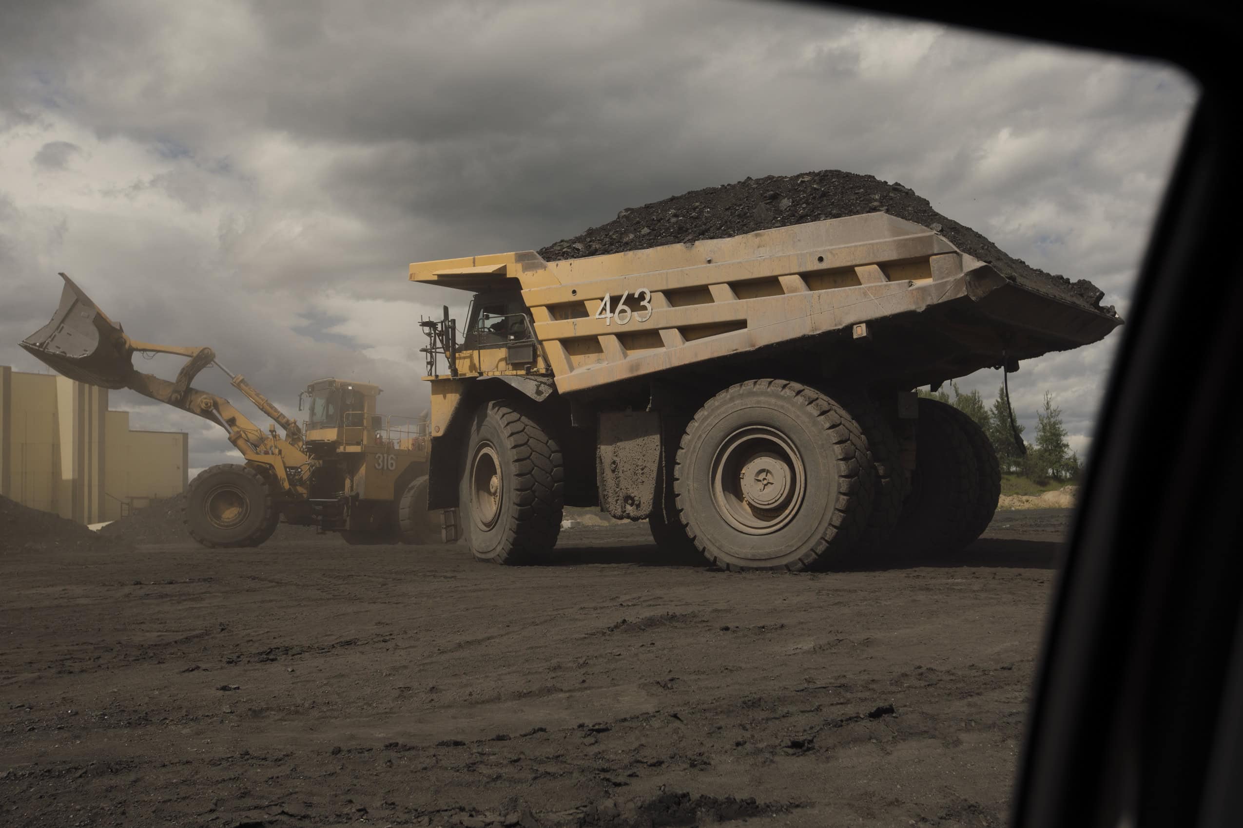 A massive mining dump truck is loaded with coal.