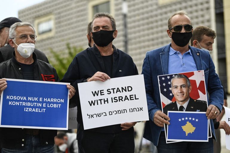 Kosovar Albanian supporters of Israel hold placards as they take part in a rally in support of Israel in Pristina on May 21, 2021. A ceasefire between Israel and Hamas, the Islamist movement which controls the Gaza Strip, came into force early May 21, after 11 days of deadly fighting that pounded the Palestinian enclave and forced countless Israelis to seek shelter from rockets. (Photo by Armend NIMANI / AFP)