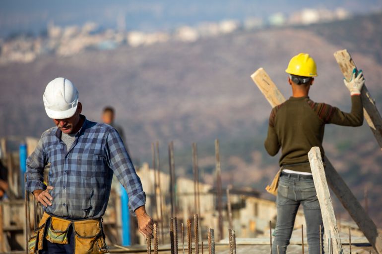 FILE - Palestinian laborers work building new houses in the West Bank Jewish settlement of Bruchin near the Palestinian town of Nablus, Monday, Oct. 25, 2021. After years in Israel’s political wilderness, small dovish parties that support Palestinian statehood and oppose Jewish settlements are back in government. But they are finding their influence is limited, with pro-settler coalition partners showing little appetite for compromise and the country's decades-long occupation churning on. (AP Photo/Ariel Schalit, File)