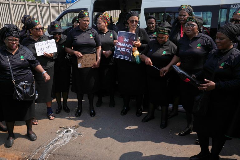 Members of a women's church group sing next to a melted candle as they pay their respects at the site where the body of a woman was discovered the previous week, in Kempton Park, South Africa, east of Johannesburg, Thursday, Sept. 17, 2026. (AP Photo/Themba Hadebe)