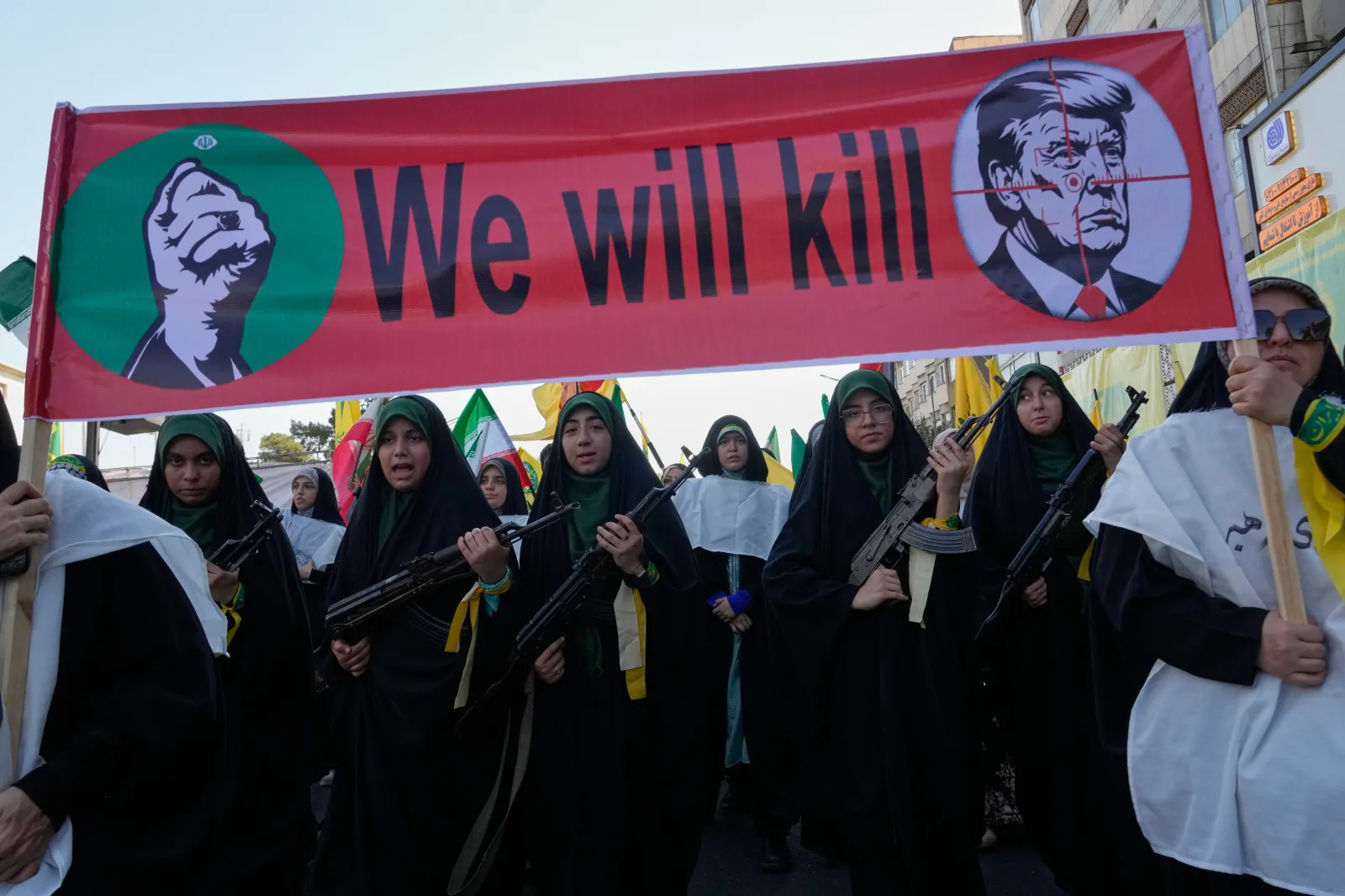 Women affiliated with Iran's IRGC carry rifles as they march beneath a banner depicting U.S. President Donald Trump in crosshairs at a parade in Tehran, Iran, on September 18.